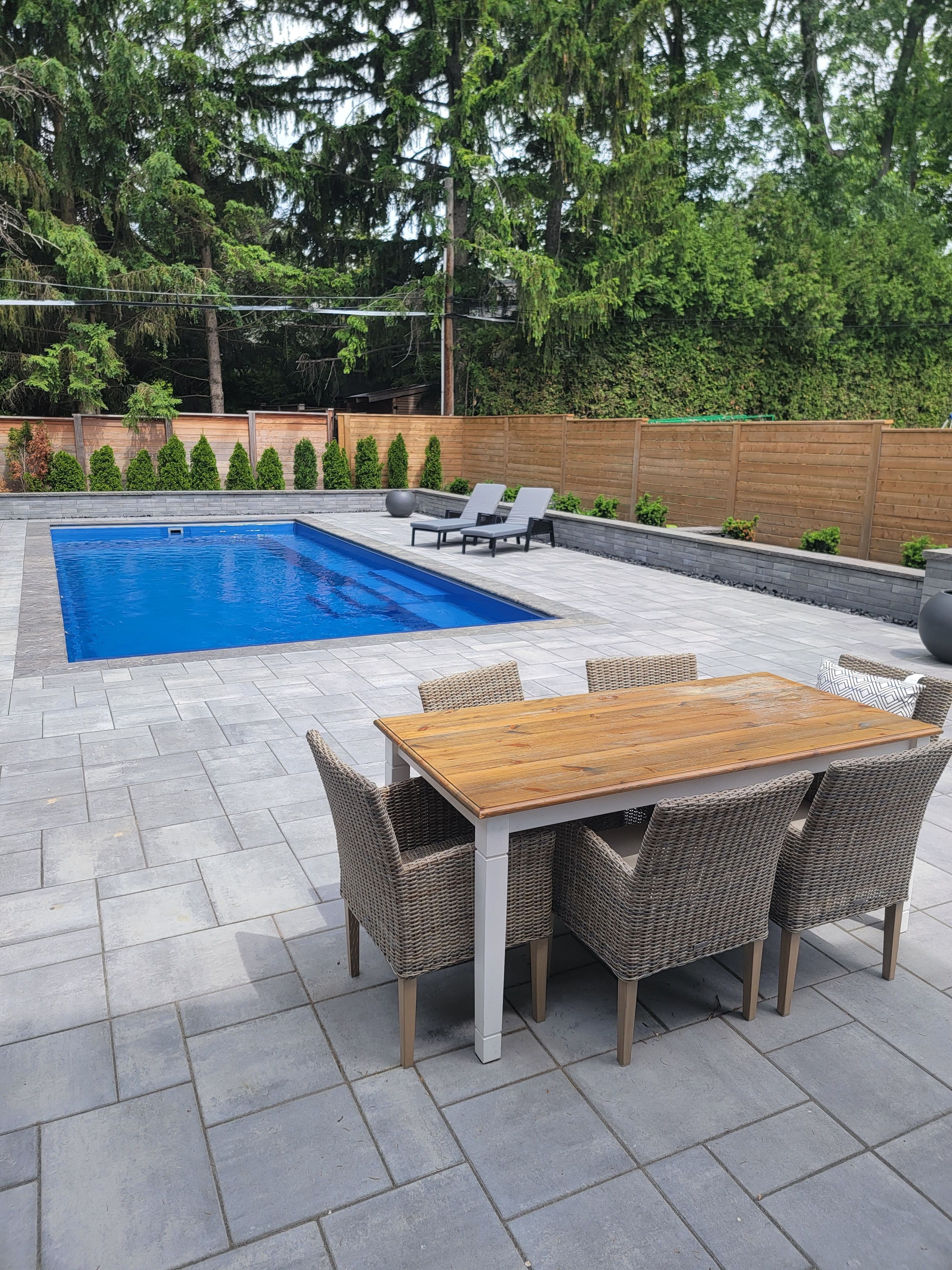 Swimmimg pool with patio and wood fence